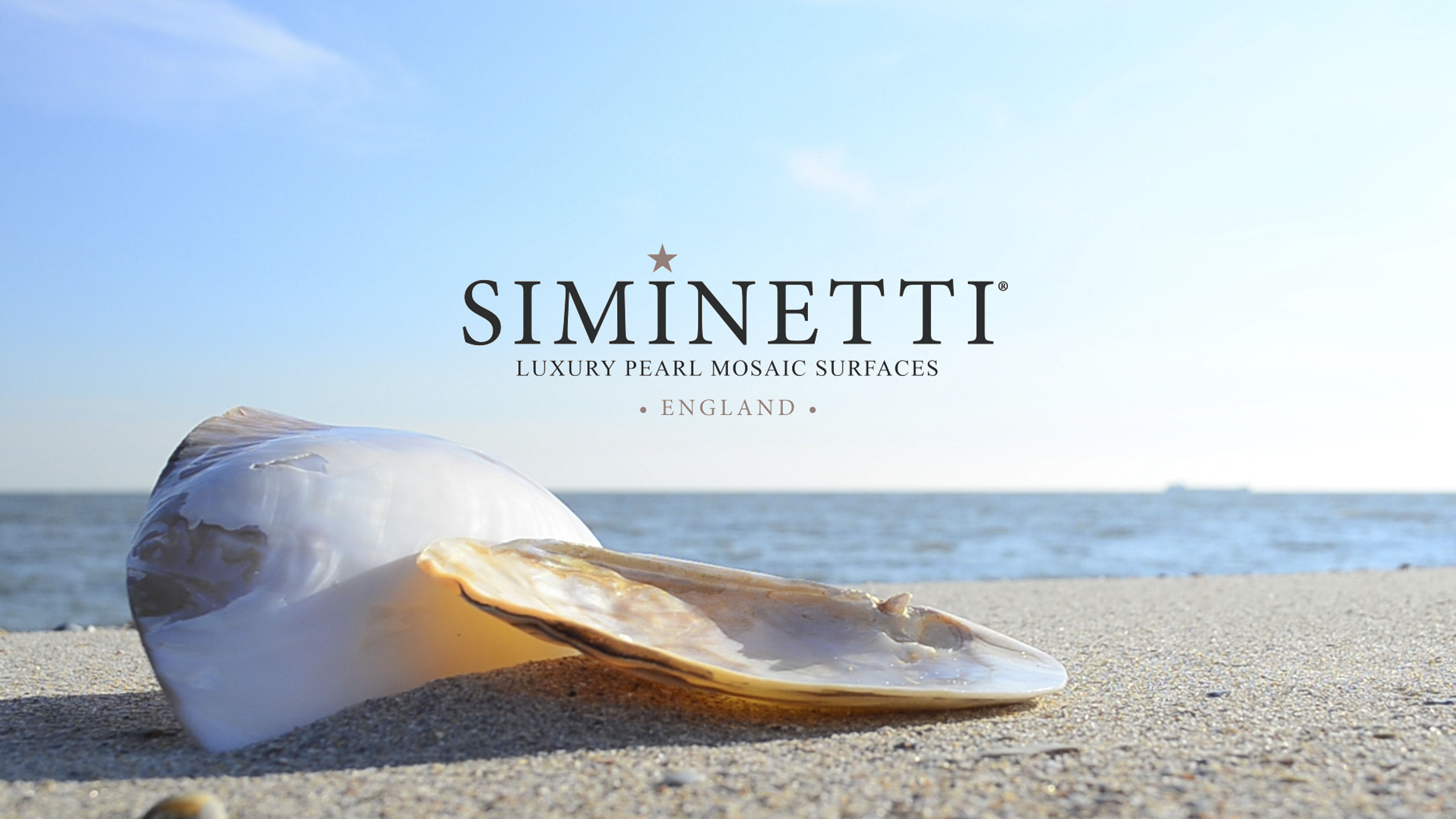 Shell on beach with Siminetti Logo